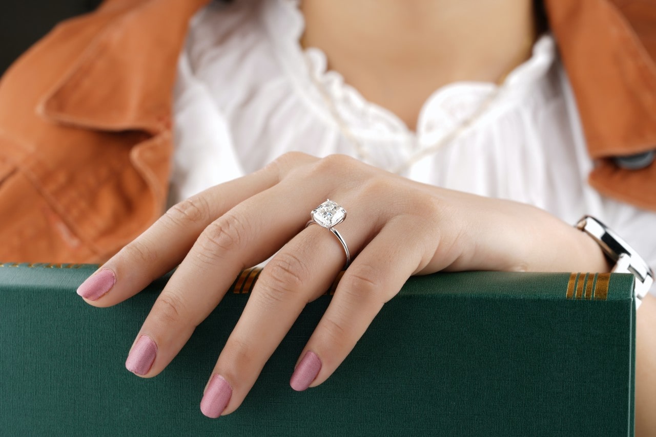 lady’s hand wearing a solitaire engagement ring