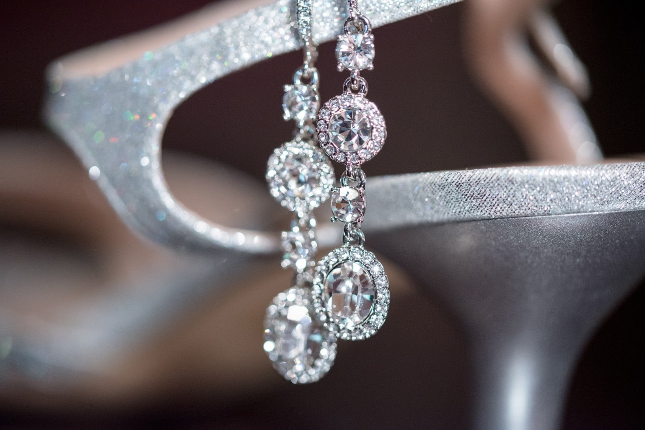 A stunning pair of diamond earrings delicately displayed on an elegant shoe.